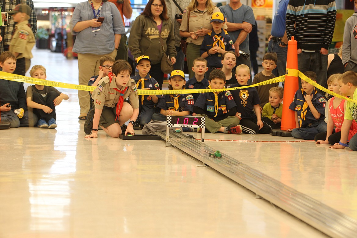 Scotty Wilde, 12, of Boy Scout Troop 202 prepares to gather the pinewood race cars Saturday after they blast down the track. Pinewood derby racing was one of several fun activities Scouts and other youngsters could do during Scouting Day in the Silver Lake Mall.
DEVIN HEILMAN/Press