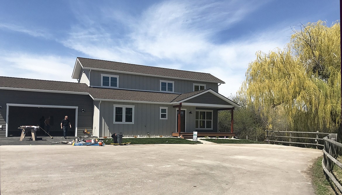 Flathead High School industrial arts and construction teacher Brock Anderson and construction student Clayton Skonord put the finishing touches on a student-built home Monday. The house, located on 125 Corporate Court, features three bedrooms and two and a half baths.