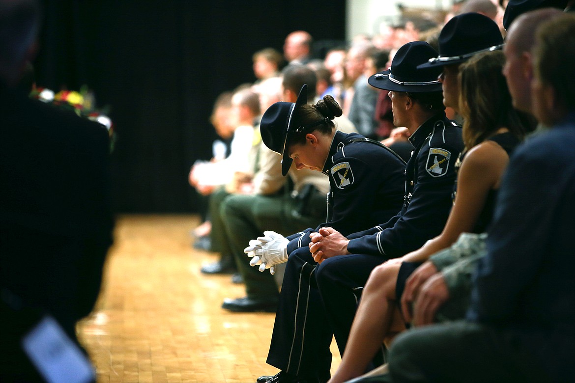 KRISTEN McPEEK/Press
An Idaho State Trooper looks to her hands during the first speech given by Pastor Rodney Wright during Sgt. Greg Moore's funeral on May 9, 2015. Law enforcement personnel from Montana, Washington, Canada and beyond attended the funeral.