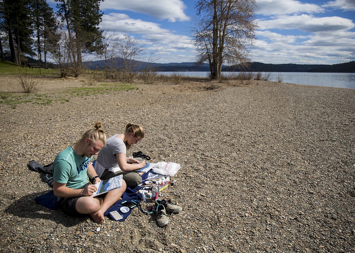 LOREN BENOIT/PressDevin Haughton and Rebecca Griffin celebrate their one year anniversary together by painting a scene at the North Idaho College Beach on Wednesday.