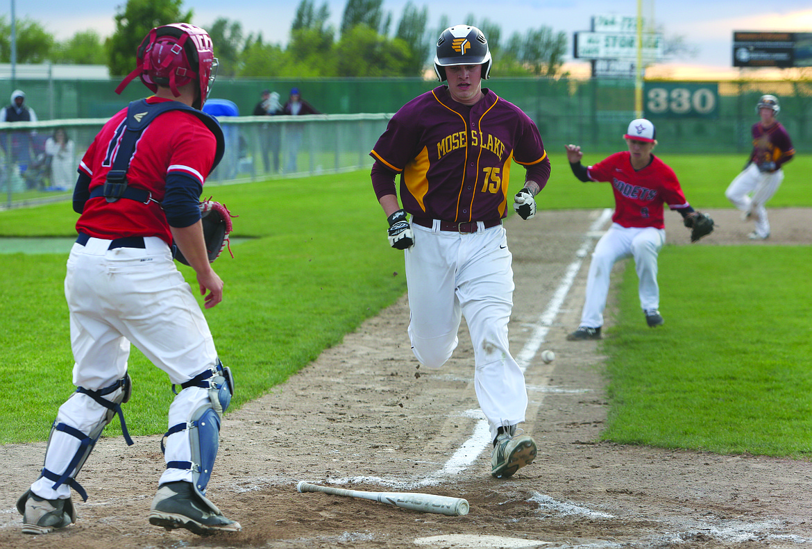 Connor Vanderweyst/Columbia Basin Herald
Moses Lake's Carter Stout comes in to score on a squeeze bunt by Cody Alvarado.