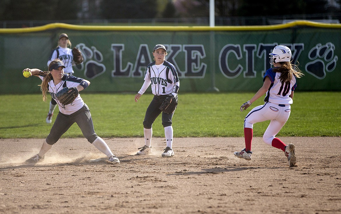 LISA JAMES/Press
Haley Lauffer of Lake City throws to first after putting out Ashley Fernimen of Coeur d&#146;Alene as Reilley Chapman stands back during the second game of their doubleheader at Lake City on Tuesday.