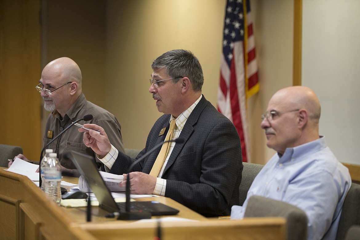 LISA JAMES/PressKootenai County Comissioner Marc Eberlein, center, flanked by commissioners Bob Bingham, left, and Chris Fillios, questions Brent Regan as they hear arguments Monday night for and against proposed changes to Citylink bus routes and fares, as well as the building of a new transit center at Riverstone.