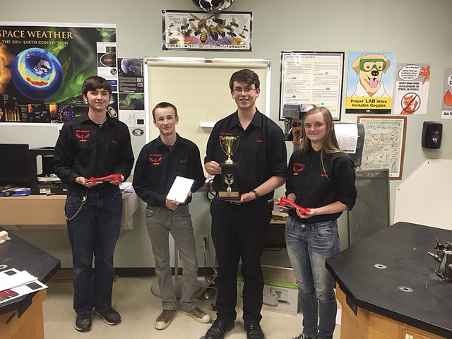 MEMBERS OF the Hot Pursuit racing team, Joshua Scrivner, left, Raferdy Samson, Chris Rosler and Jenny Scrivner show off their hardware at Hot Springs High School on Wednesday. The team took third place at the state F1 in Schools tournament and will travel to Austin, Texas to compete at the national finals in June. (Brett Berntsen/Lake County Leader)