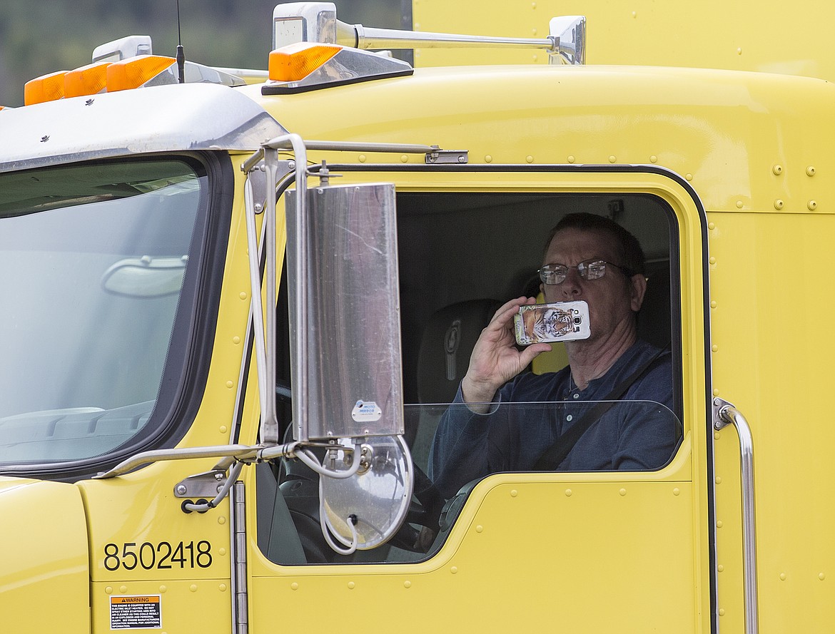 LOREN BENOIT/Press
A truck driver records a video while driving by the scene of a derailed train Monday morning near Cocolalla.