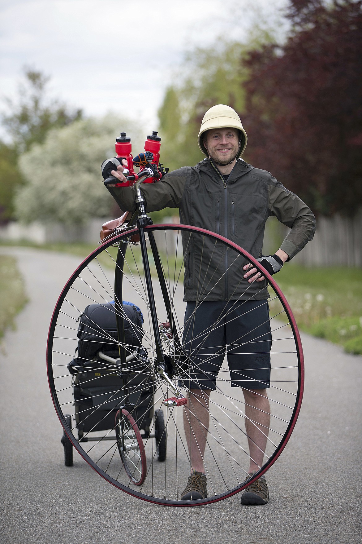 LISA JAMES/PressLocal adventurer Julian Redman stands with his penny-farthing bicycle on the bike path near his apartment off of Kathleen Ave. in Coeur d'Alene on Wednesday. Redman will be embarking on a cross-country trip Friday from San Francisco, following the path of Thomas Stevens, the first person to ride a bike across America in 1884. Redman's bicycle is a custom built replica of the bike Stevens rode.