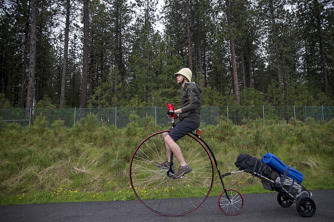 LISA JAMES/PressLocal adventurer Julian Redman rides his penny-farthing bicycle on the bike path near his apartment off of Kathleen Ave. in Coeur d'Alene on Wednesday. Redman will be embarking on a cross-country trip Friday from San Francisco, following the path of Thomas Stevens, the first person to ride a bike across America in 1884. Redman's bicycle is a custom built replica of the bike Stevens rode.