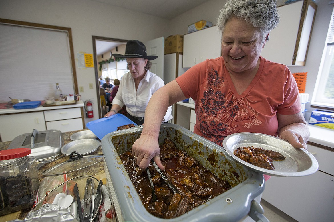 LISA JAMES/PressCindy Dupuis, right, plates ribs as chef Robin McKellar loads up a tray to serve members of BAB (Bayview Athol Belmont) during their Wild West Social at the community center in Bayview on Tuesday.