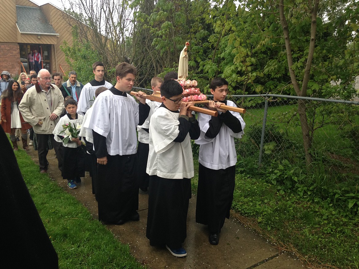 JASON ELLIOTT/Press
St. Stanislaus Church altar boys Gabriel Rasmus, Andrew Lopez, Michael Johnson and Cody Visenheimer, back, carry the Blessed Virgin Mary into the church during a procession on Sunday morning in celebration of the 100th anniversary of Our Lady of Fatima.