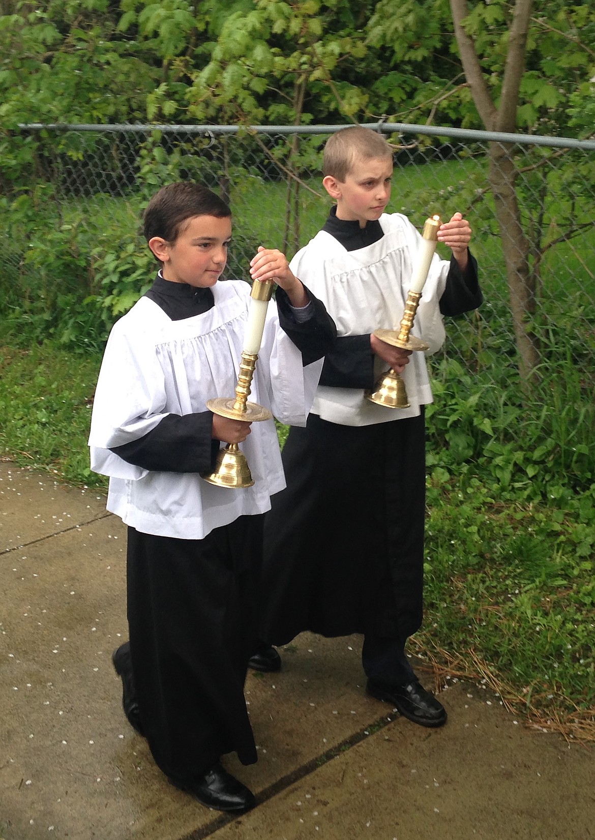 JASON ELLIOTT/Press
Toby Guatamini, left, and Thomas Perry, attempt to fight off the rain and keep their candles lit during the St. Stanislaus' Catholic Churches Our Lady of Fatima procession on Sunday in Rathdrum.