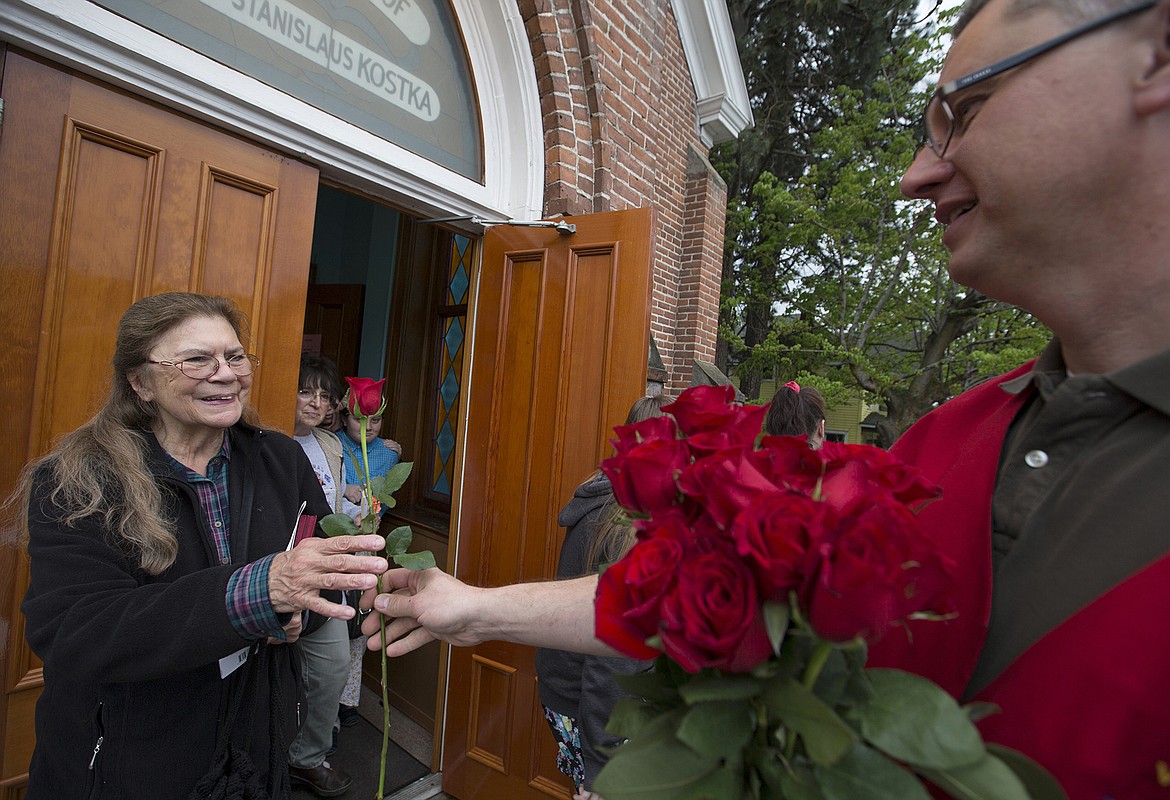 LISA JAMES/PressVince Perry hands out roses to the mothers of St. Stanislaus Church in Rathdrum during their annual Mother's Day service and breakfast on Sunday. A special mass was also held for the anniversary of Our Lady of Fatima.