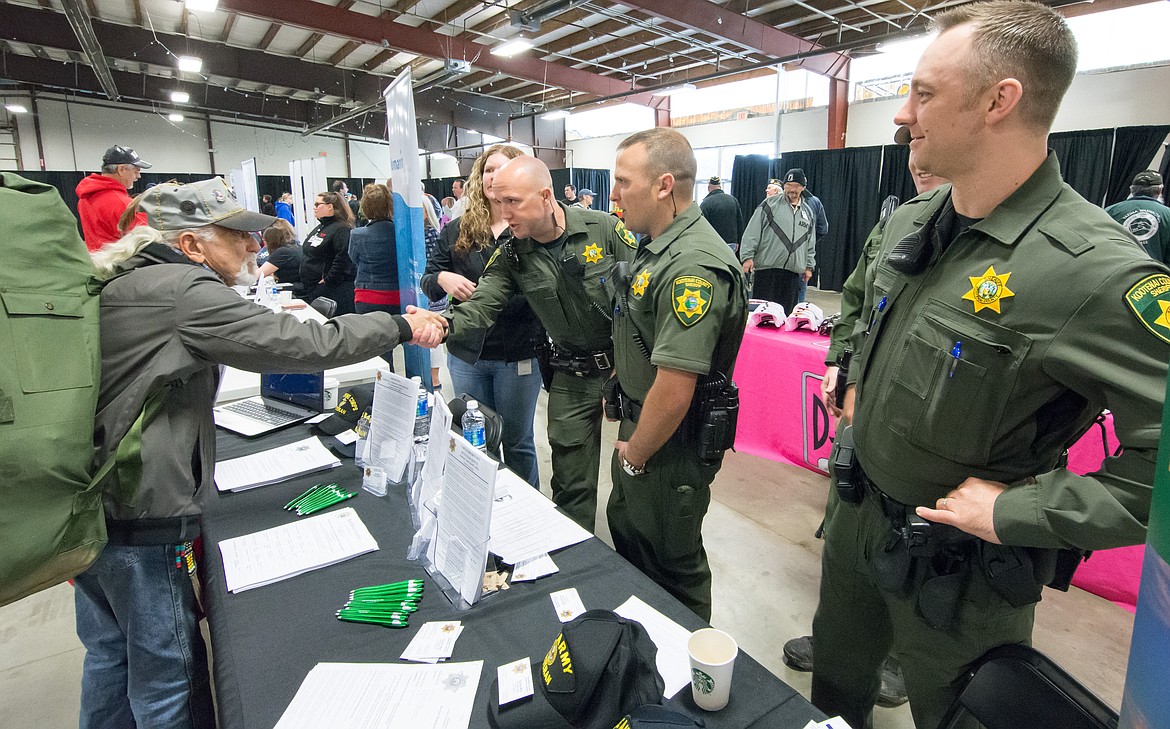CHRIS CHAFFEE/Special to The Press
Members of the Kootenai County Sheriff's Office thank homeless Air Force veteran Jim Gavras for his service Saturday during the annual North Idaho Veterans Stand Down at the fairgrounds.