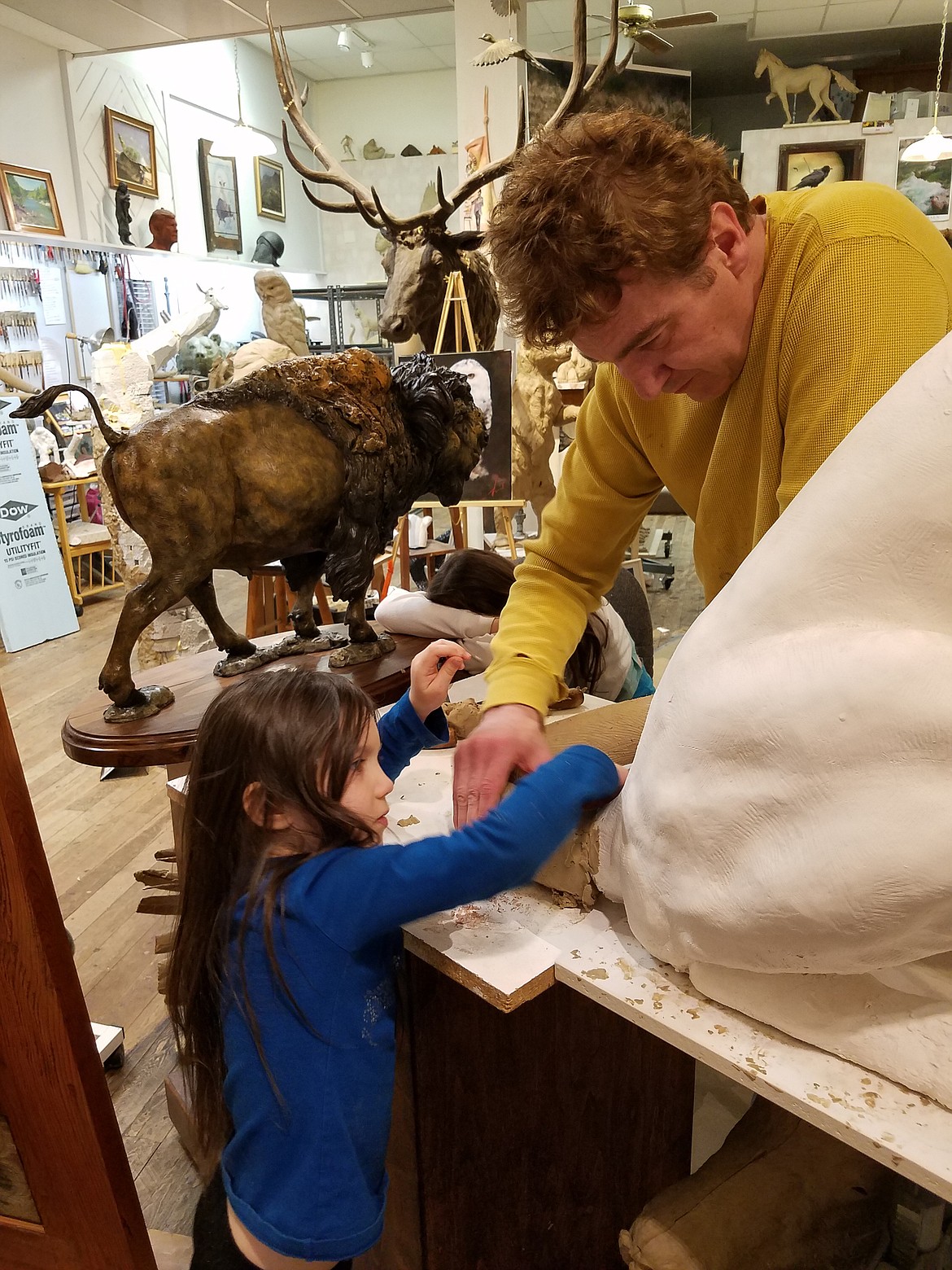 SCULPTOR ERIC Thorsen works on the tail of &#147;Sitting Panther&#148; with one of his daughters. (Courtesy photo)