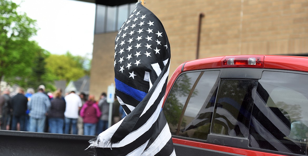 An American Thin Blue Line flag waves in the wind as participants gather for a vigil Broadwater Deputy Sheriff Mason Moore was held outside the Flathead County Sheriff&#146;s Office on Wednesday evening, May 17, in Kalispell. The altered flag is meant to represent support for law enforcement officers who are referred to as &#147;the thin blue line&#148; because of the traditional color of their uniforms.(Brenda Ahearn/Daily Inter Lake)