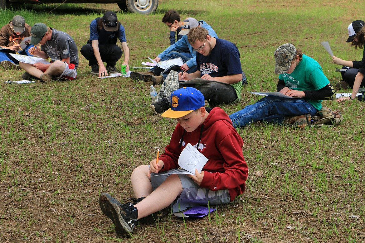 (Photo by MARY MALONE)
Cole Reuter, front, seventh-grader at Clark Fork Junior/Senior High School, works on the in-depth map reading test in the junior/senior division of the 35th annual Idaho State Forestry Contest Thursday in Careywood.