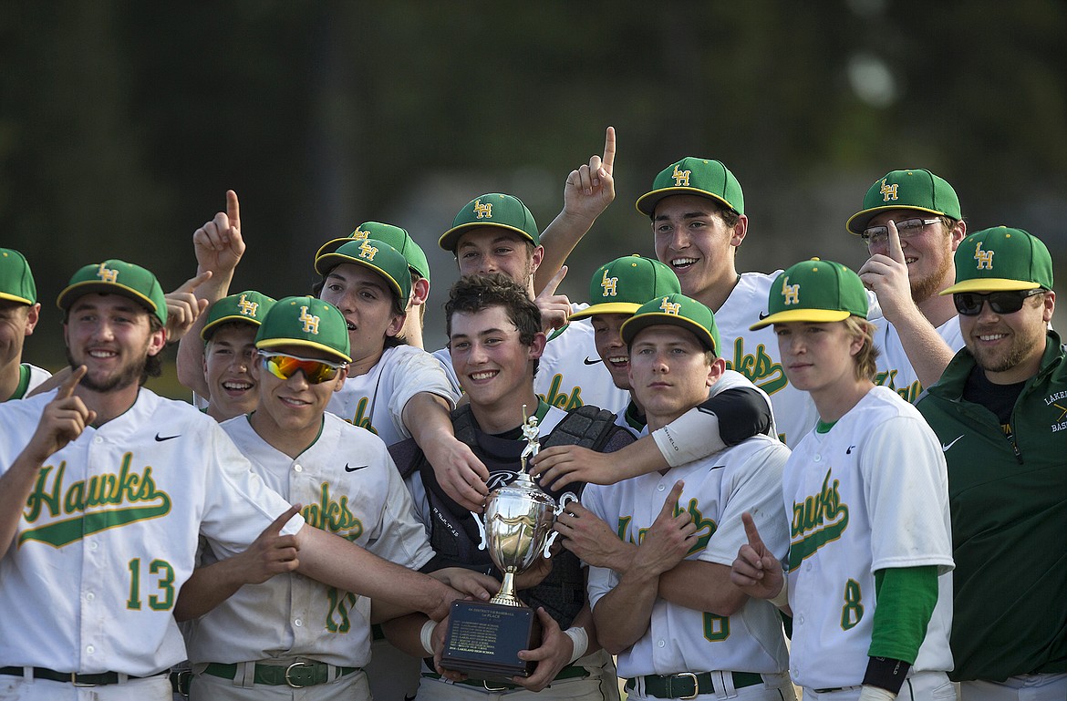 LISA JAMES/Press
Lakeland players hold up their  4A Region 1 baseball championship trophy after their win over Sandpoint at Lakeland High School on Wednesday. Lakeland now moves on to the state championships.