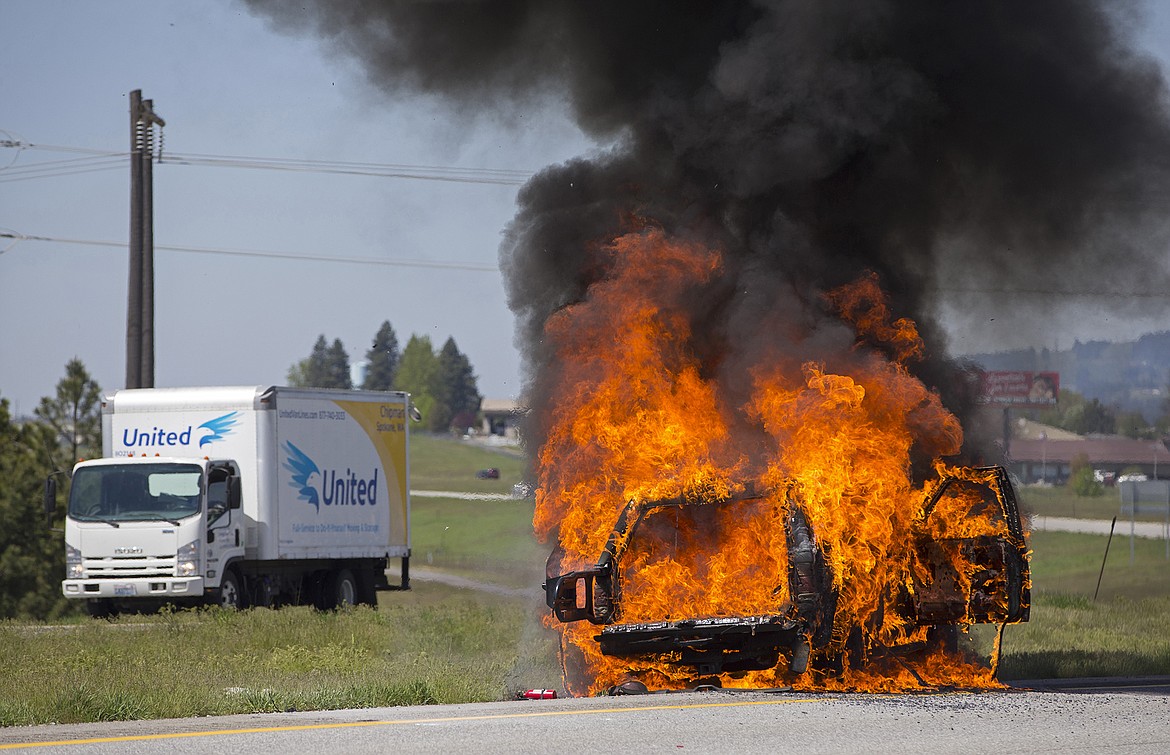 LISA JAMES/Press
Traffic slows as a 1994 Honda Passport burns in the median along Highway 90 near Exit 2 in Post Falls on Wednesday morning.  The car caught fire while the drivers were traveling west back to Sandwood, WA. They were able to escape before the car was engulfed.