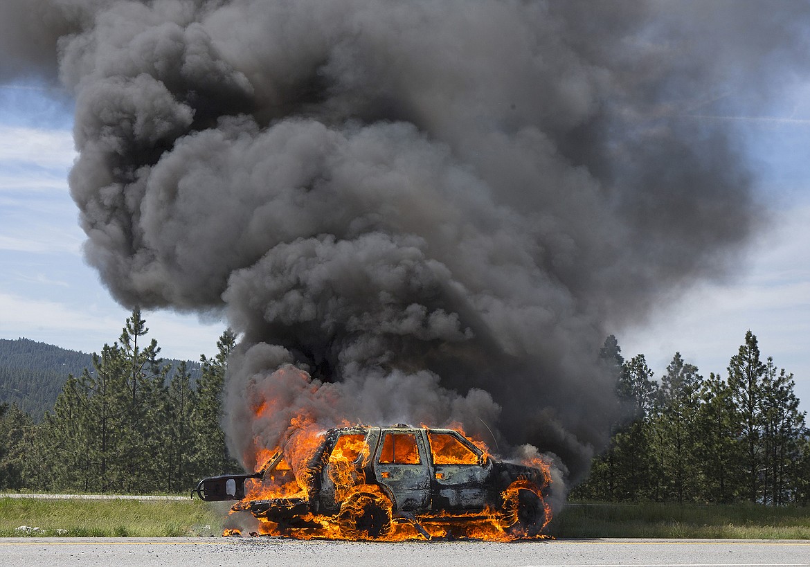 LISA JAMES/Press
A 1994 Honda Passport burns in the median along Highway 90 near Exit 2 in Post Falls before firefighters show up on Wednesday morning.  The car caught fire while the drivers were traveling west back to Sandwood, WA. They were able to escape before the car was engulfed.
