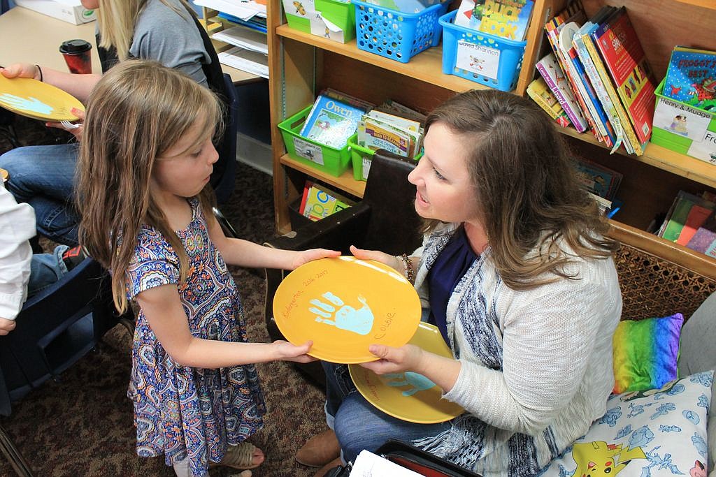 Charles H. Featherstone/Columbia Basin Herald - Wilson Creek kindergarten teacher Megan Walter hands Colbie Didericksen a plate she made for her parents as part of the Mother and Father Tea on Friday.