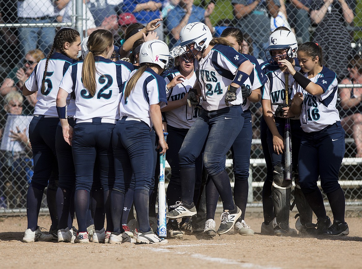 LOREN BENOIT/Press
Haley Loffer (24) of Lake City High School is mobbed at home plate after hitting a home run in the 5A Region 1 championship game against Coeur d&#146;Alene High on Tuesday. The host Timberwolves defeated the Vikings 3-2.