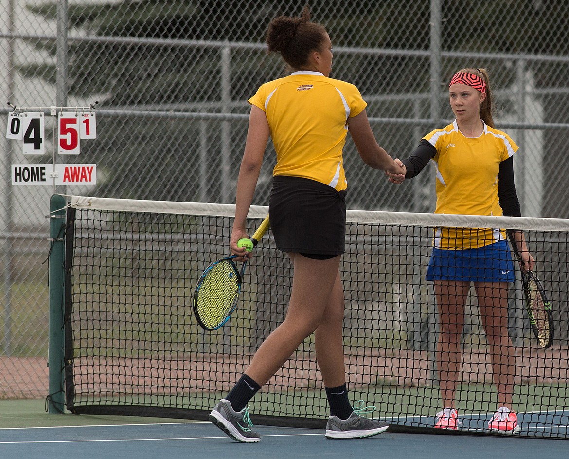 Mehki Sykes and Isabelle Martineau shake hands after a divisional match Friday in Libby. (John Blodgett/The Western News)