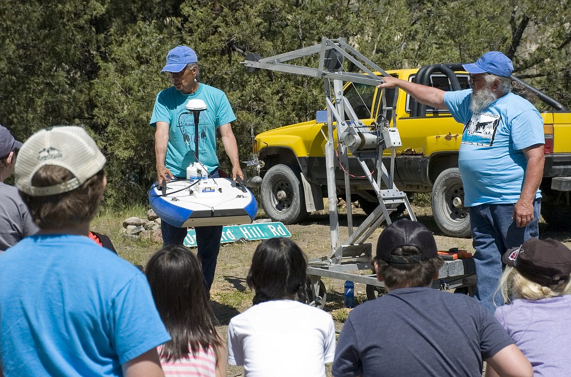 Hydrologist Martin Barnaby, left, and George McCloud with the CSKT Division of Water teach fourth grade students from Linderman Elementary how they use technology like radio-controlled boats to monitor stream flow. (Brett Berntsen/Lake County Leader)