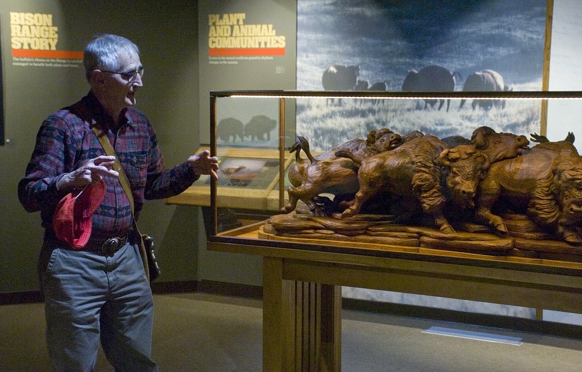 ARTIST JOHN Sharp describes his wood carving, which was donated to the National Bison Range, during an unveiling ceremony on Friday.