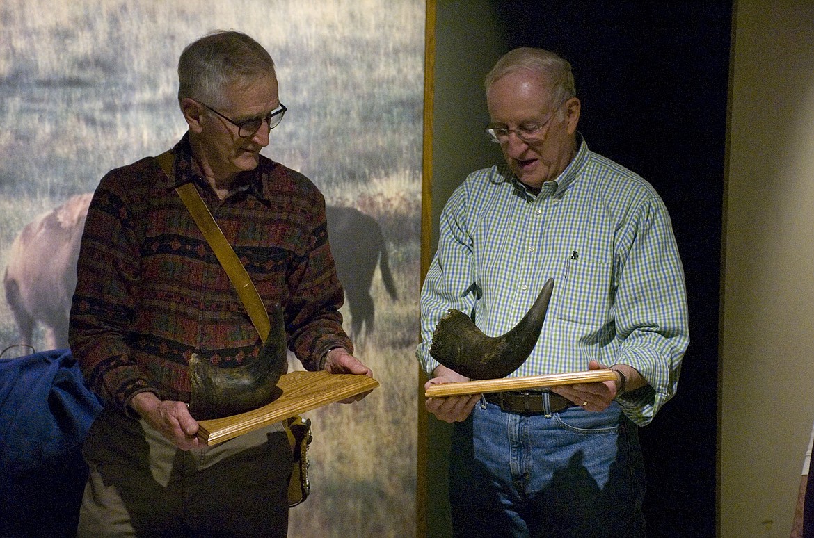 JOHN SHARP, left, and Jim Kackney receive  mounted bison horns on Friday for their donation of a wood carving to the National Bison Range.