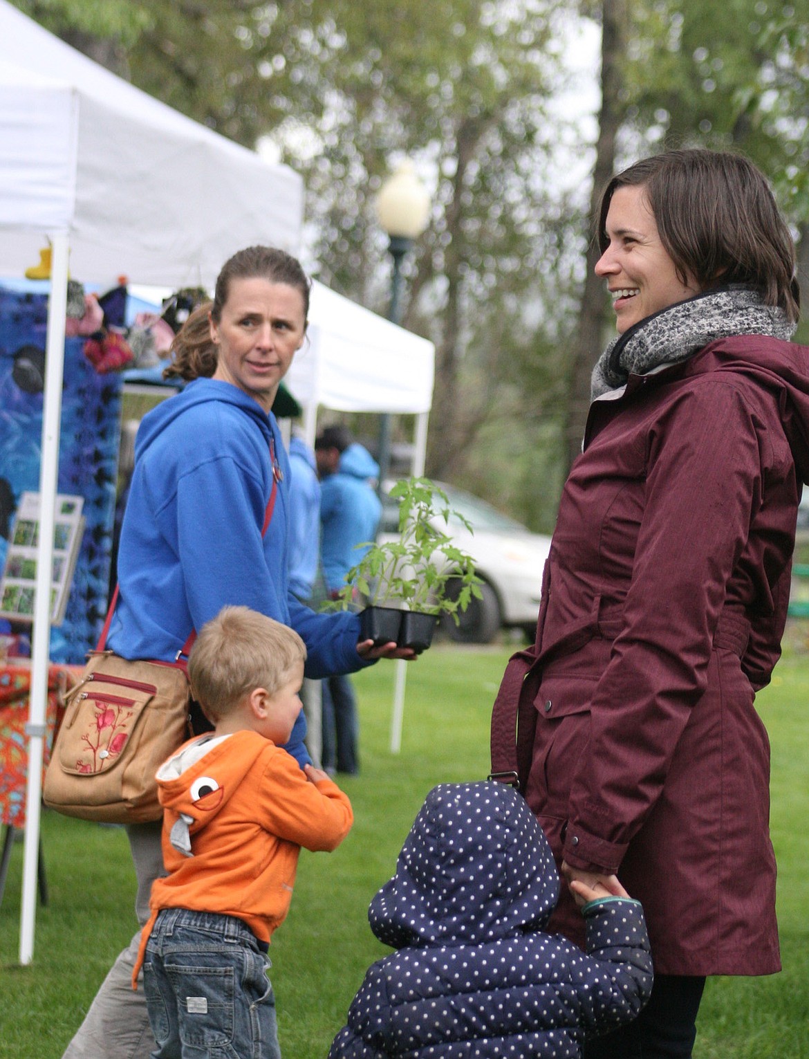 Troy Farmers Market manager Shawna Kelsey, foreground, holding Calliope Karuzas&#146; hand, and customer Shana Bernall, background, with son Glade Bernall.