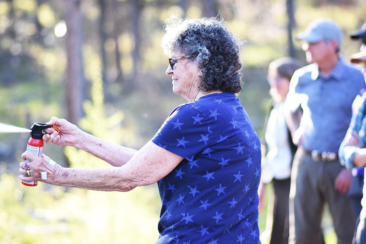 Virginia Feiker practices good form with bear spray at a recent &#147;Bear Aware&#148; hike on the Whitefish Trail. (Daniel McKay/Whitefish Pilot)