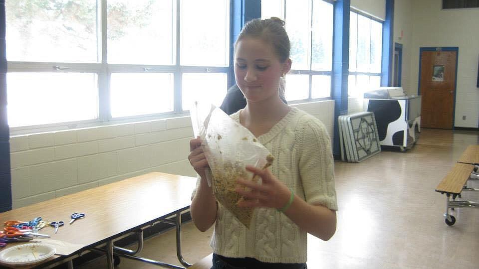 Photo by SYDNEY DENNIS
A young Hannah Sims makes a bird feeder (seeds on a pinecone) during her time spent in the Young Miss Program.