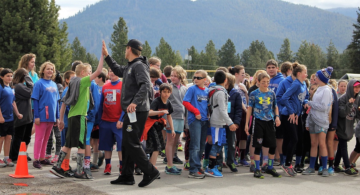 St. Regis Senior, Brock Cantrell-Field gives the fifth and sixth graders high-fives before the start of their 5K run during the Fun Run. (Kathleen Woodford/Mineral Independent).