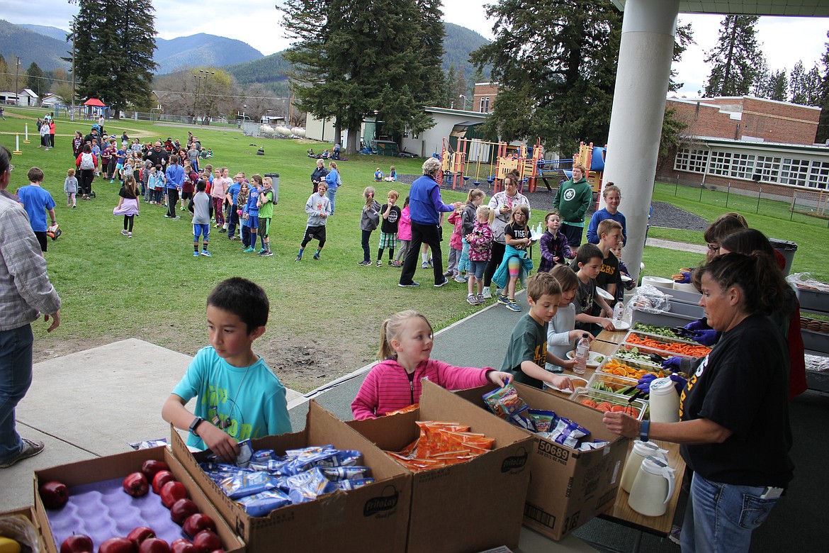 Students line up for a lunch of sandwiches, fruit and vegetables after their 1-mile and 5K races during the Fun Run in St. Regis. (Kathleen Woodford/Mineral Independent).