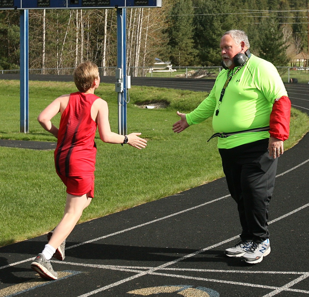 (Photo by ERIC PLUMMER)
Ross gives a high five to a 3,200 finisher at the Clark Fork meet last week, as he did to all of the long distance finishers.