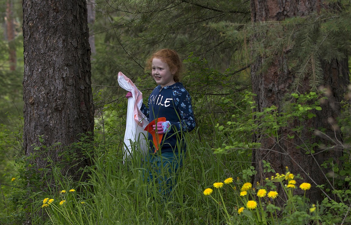 LISA JAMES/Press
John Brown Elementary School first-sgrader Hazel Nutterville tromps through tall grass looking for trash on a litter cleanup with her class on Thursday, May 18.
Local environmental activist Dylan Stiegemeier, who started The Theodores, went out with students and teachers to clean up a patch of woods near the school, after teaching them about littering and recycling.