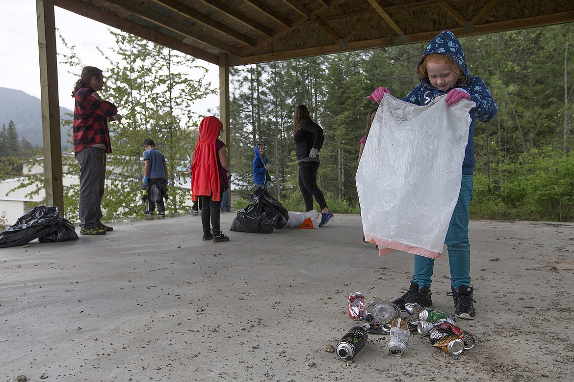 LISA JAMES/Press
John Brown Elementary School first-grader Hazel Nutterville dumps out her bag of recyclables to count them after a litter cleanup with her class on Thursday, May 18.
Local environmental activist Dylan Stiegemeier, left, who started The Theodores, went out with students and teachers to clean up a patch of woods near the school, after teaching them about littering and recycling.