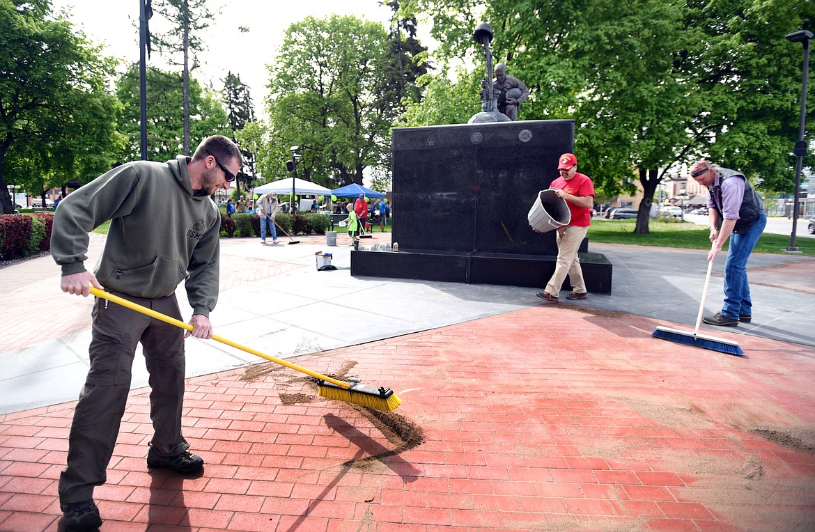 From left, Adam Strash, Tim Norton and Victor Nelson of the Flathead Marines clean the Veterans Memorial in Depot Park on Saturday, May 20. Every year the Flathead Marines clean the monument the week before Memorial Day. (Brenda Ahearn/Daily Inter Lake)