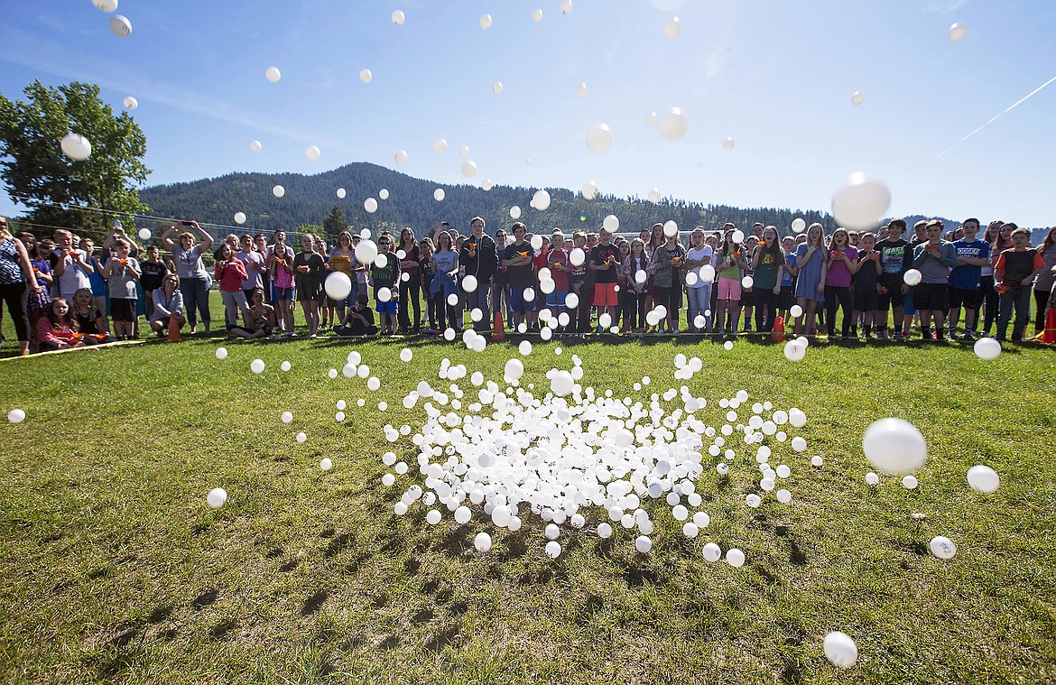 LISA JAMES/Press 
Pingpong balls rain down from 40 feet above the ground Monday morning while students watch at Canfield Middle School in Coeur d&#146;Alene. The balls, dropped from a cherry picker by Canfield Principal Nick Lilyquist, were sold for $5 each to raise $4,500 for a PTA fundraiser. The students who sold the balls were invited to watch them drop while eating snowcones. Prizes were awarded for the balls that landed closest and farthest from a hole.