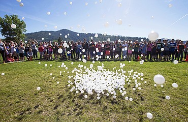 LISA JAMES/Press 
Pingpong balls rain down from 40 feet above the ground Monday morning while students watch at Canfield Middle School in Coeur dAlene. The balls, dropped from a cherry picker by Canfield Principal Nick Lilyquist, were sold for $5 each to raise $4,500 for a PTA fundraiser. The students who sold the balls were invited to watch them drop while eating snowcones. Prizes were awarded for the balls that landed closest and farthest from a hole.