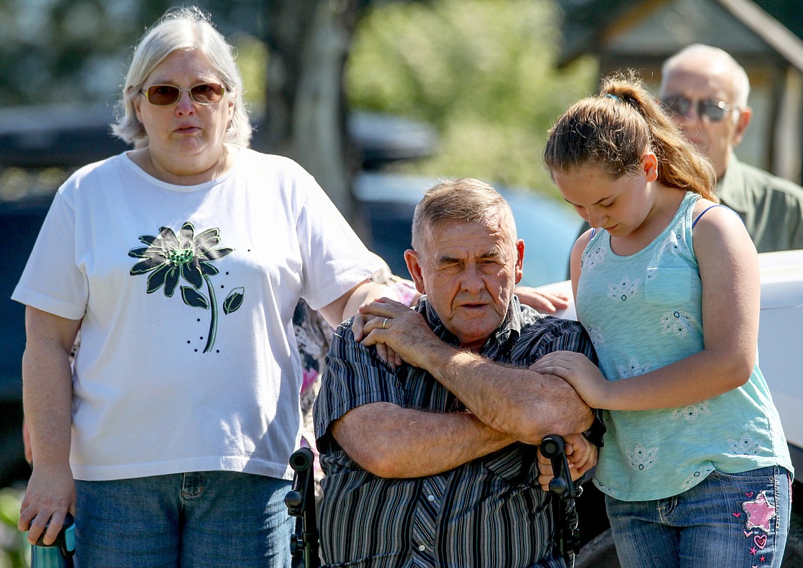 Libby residents Faith Siefke, left, her husband Tim Siefke and their granddaughter Kaylin Siefke stand during a moment of prayer at a Memorial Day ceremony at Libby Cemetery Monday, May 29, 2017. (John Blodgett/The Western News)