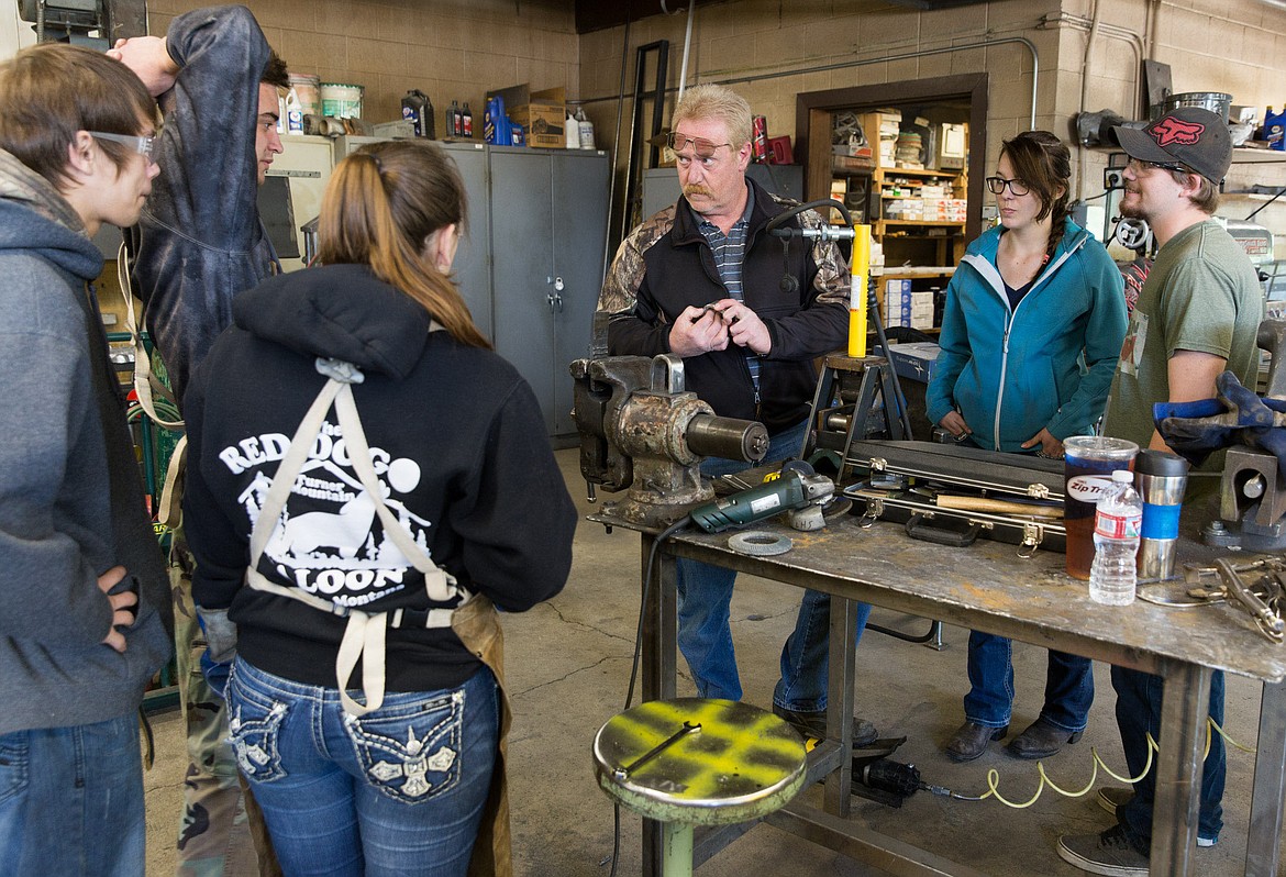 Mort Hill, center, of Flathead Valley Community College, judges &#147;the bend test&#148; during a welding certification class at Libby High School Friday, May 19, 2017. Students are, left to right: Mason Sams, Mathew Agresta, Missy Vandeberg, Terina Wisdom and Tyler Freeman. (John Blodgett/The Western News)