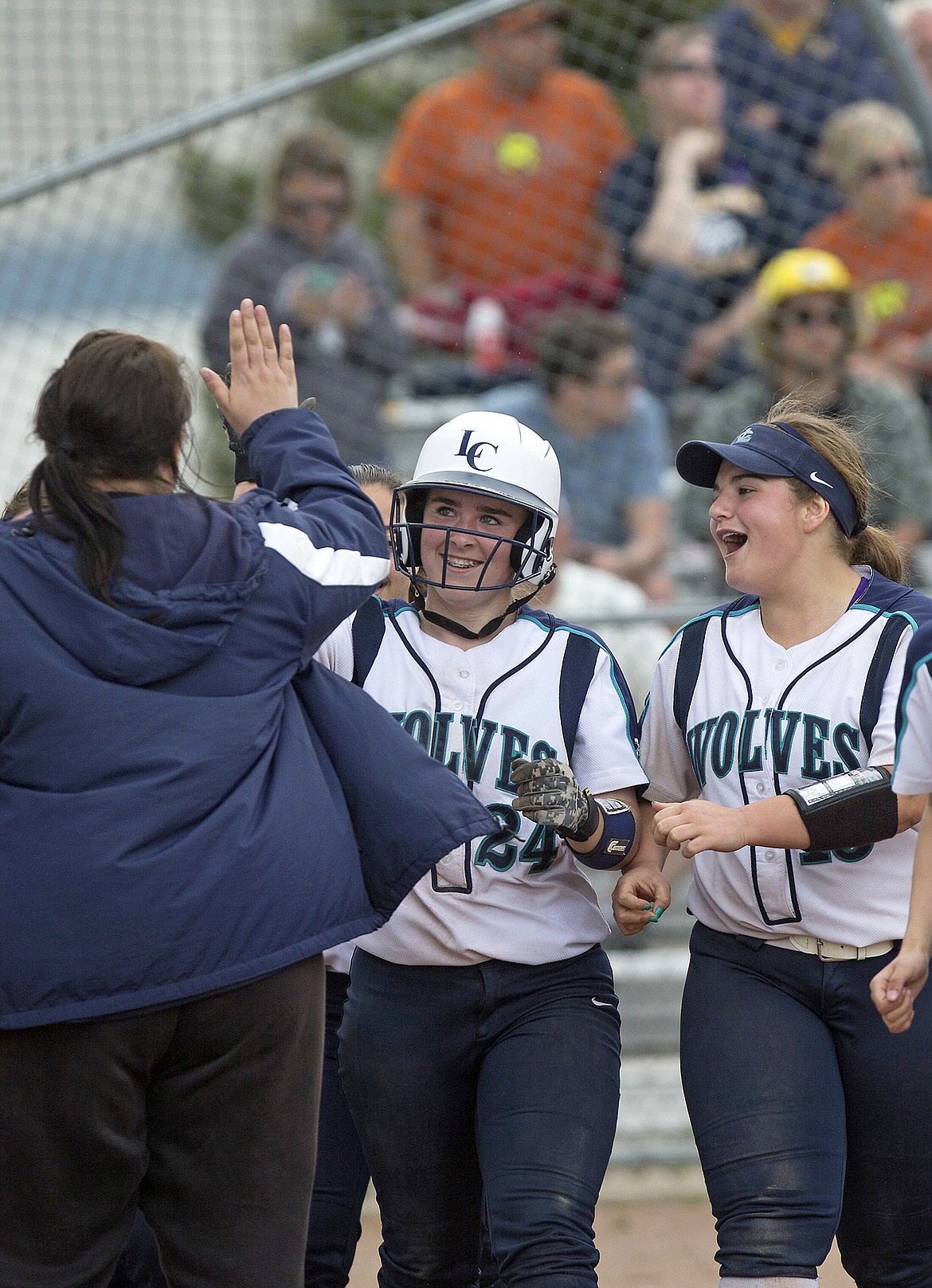 LISA JAMES/Press
ABOVE LEFT: Haley Loffer of Lake City gives assistant coach Amanda Krier a high-five, as Reilly Williams celebrates after Loffer&#146;s home run put them ahead of Meridian 8-2 in the sixth inning during the first game of the state 5A softball tournament Friday at Coeur d&#146;Alene High School.
ABOVE RIGHT: Haley Loffer&#146;s dad, Jeremy Loffer, left, and stepdad, David Hunt, fist bump each other after Loffer&#146;s home run.