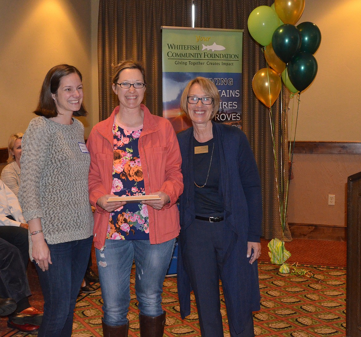 Katie Ward and Gloria Nelson, representing Project Whitefish Kids, accept the Doris Schumm Community Spirit Award from Linda Maetzold.