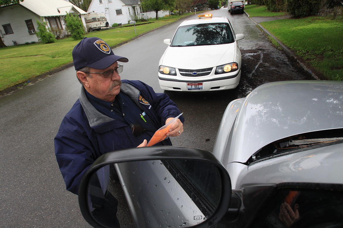 RALPH BARTHOLDT/Press
Volunteer Jim Strinz tags a pickup truck that has been abandoned with a flat tire on a Coeur d&#146;Alene residential street.