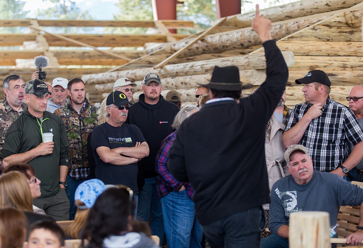 Auctioneer Jake Yoder, foreground, auctions a log cabin at the Libby Amish community Saturday.