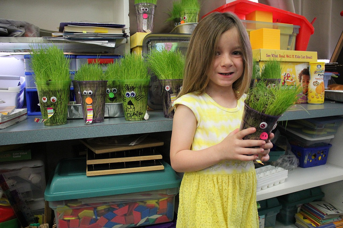 The Superior kindergarten class made crazy grass people to show how grass grows. Seeds were planted in plastic cups and faces were made with the grass becoming the &#147;hair.&#148; When it got too long, the kids were able to give their crazy cup people a haircut. Here, Superior kindergartener Roxanne Main holds her crazy cup person with long grass hair. (Kathleen Woodford/Mineral Independent).