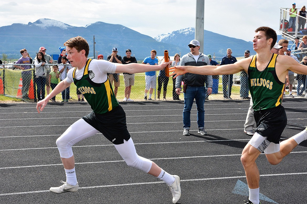 Tyler Cote takes the baton from Lee Walburn during the 1,600m relay at the Western A divisional meet in Corvallis. (Photo courtesy Jeff Doorn)