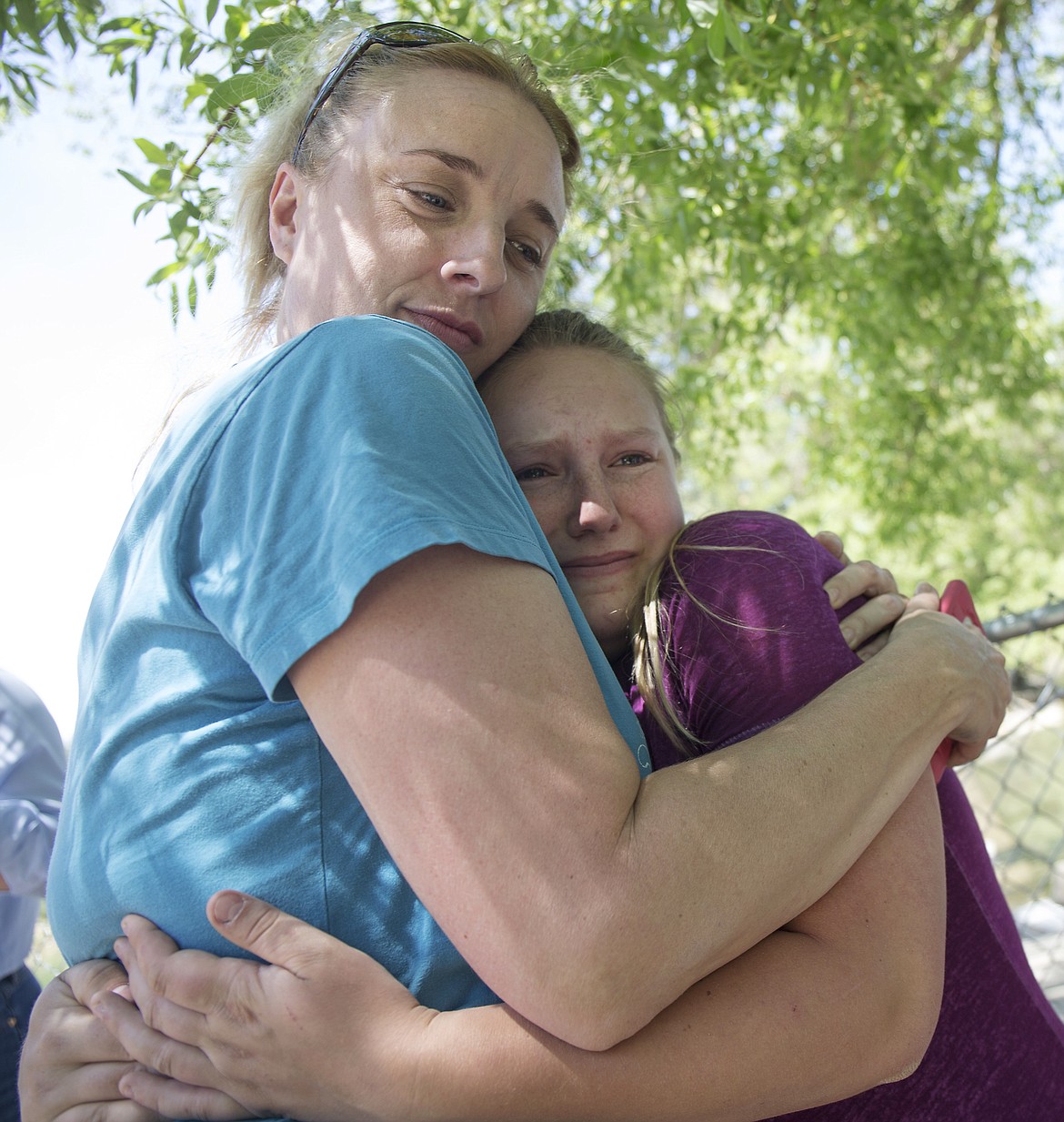 LISA JAMES/Press
Missy Holbrook hugs animal rescuer Toni Hammer on Tuesday after Hammer hung a memorial sign for Holbrook&#146;s dog, Bear, at the spot where Bear drowned after being pulled down agains a drainage grate in Hayden Lake Monday.