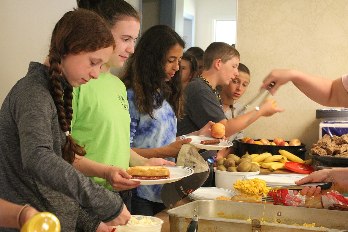 Students gather for a lunch of hot dogs and macaroni before their afternoon lessons at Outdoor School. (Kathleen Woodford/Mineral Independent).