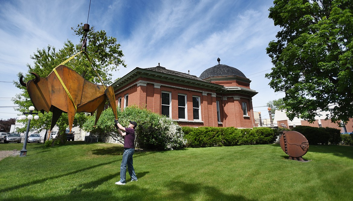 SCULPTOR MANEL &Agrave;lvarez helps with the installation of three recently completed iron bison sculptures on Tuesday afternoon, June 6 at the Hockaday Museum of Art. (Brenda Ahearn/Daily Inter Lake)